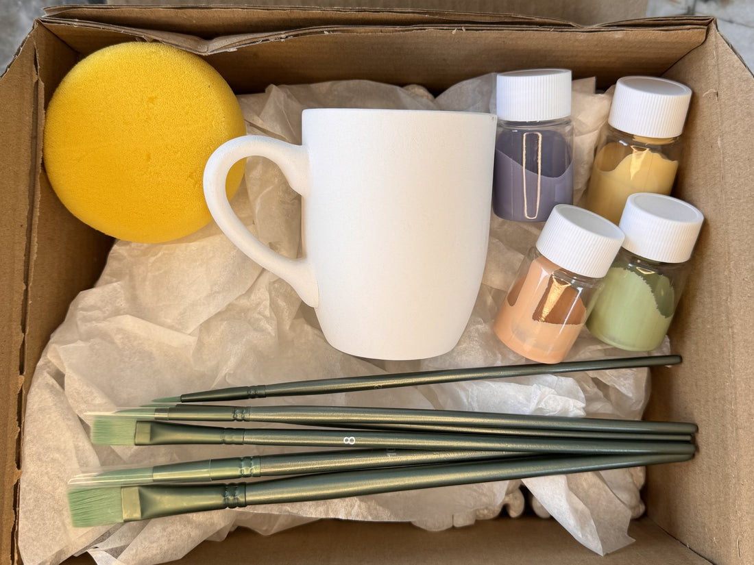 Contenu de la Box céramique à peindre Studio Séleste : mug en céramique brute, pots de couleur, pinceaux et éponge